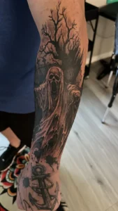 black and gray ghost in the trees arm tattoo jeff thibodaux tattootopia