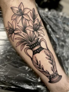 black and gray lilies in an urn leg tattoo jeff thibodaux tattootopia