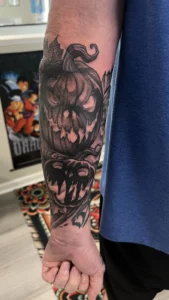 black and gray pumpkin monster forearm tattoo jeff thibodaux tattootopia