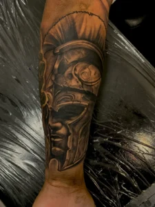 black and gray roman warrior helmet forearm tattoo jeff thibodaux tattootopia