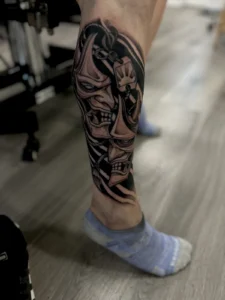 black and gray theater masks leg tattoo jeff thibodaux tattootopia