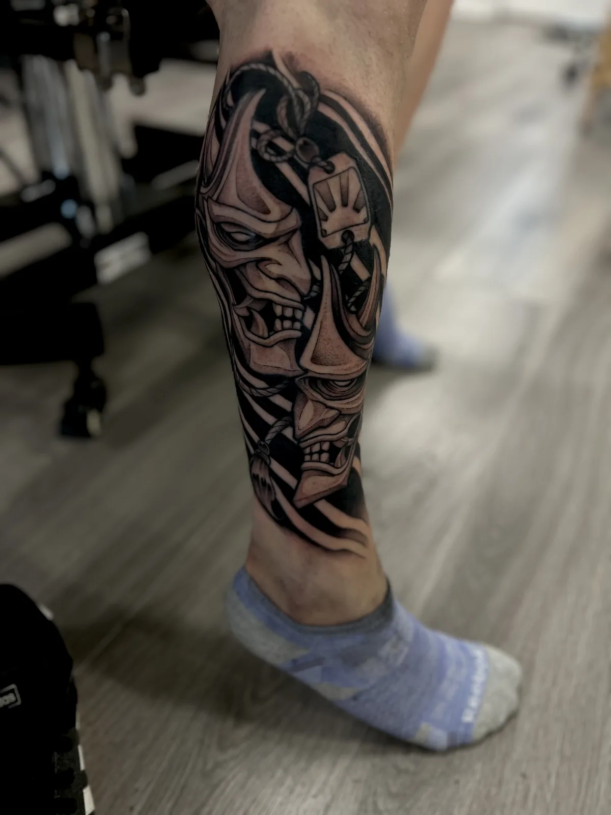 black and gray theater masks leg tattoo jeff thibodaux tattootopia