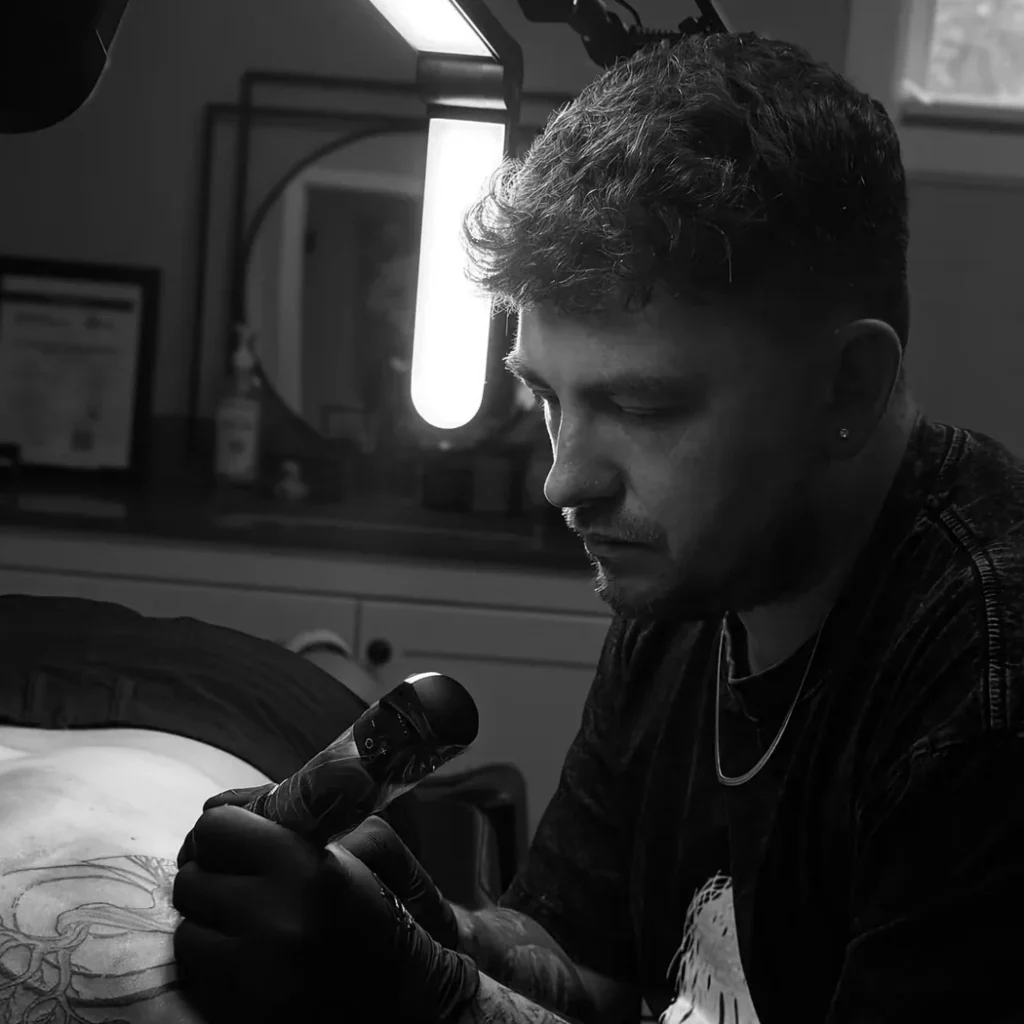 Jeff Thibodaux tattooing a client at Tattootopia in Denham Springs