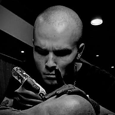 Josh Lockhart tattooing a client at Tattootopia in Denham Springs