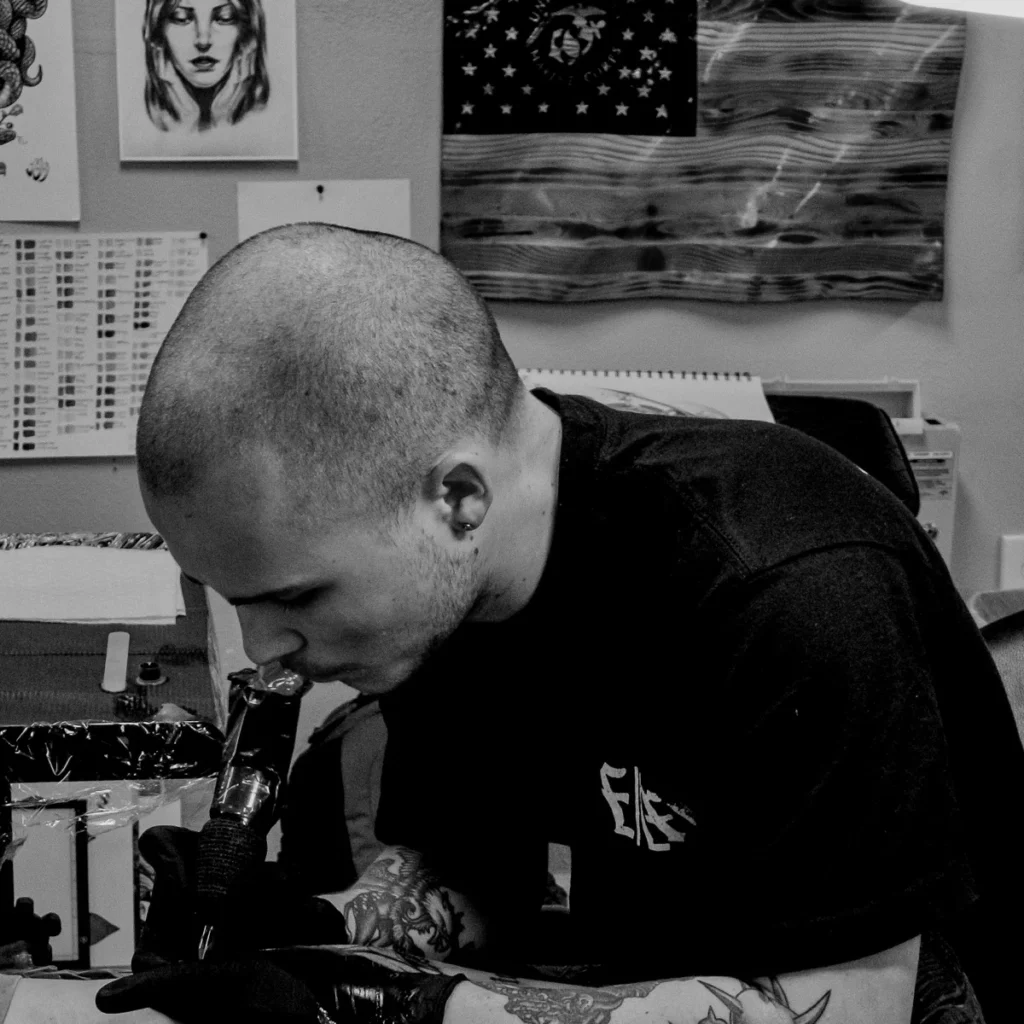 Josh Lockhart tattooing a client at Tattootopia in Denham Springs